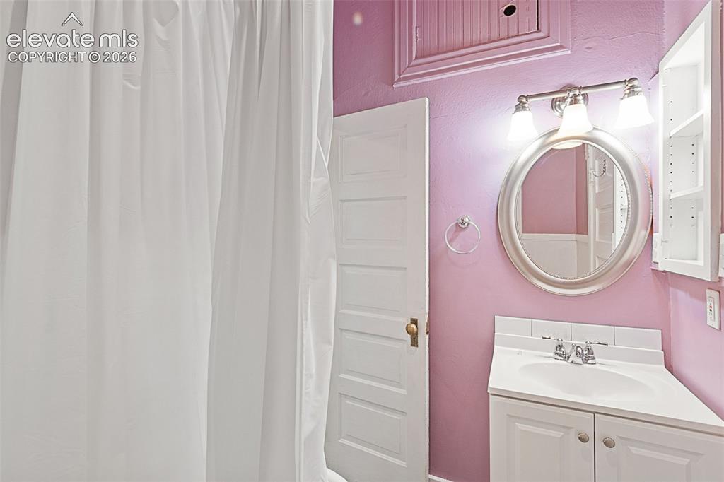 Image 28 of 38: Secondary main level bath with clawfoot tub and shower