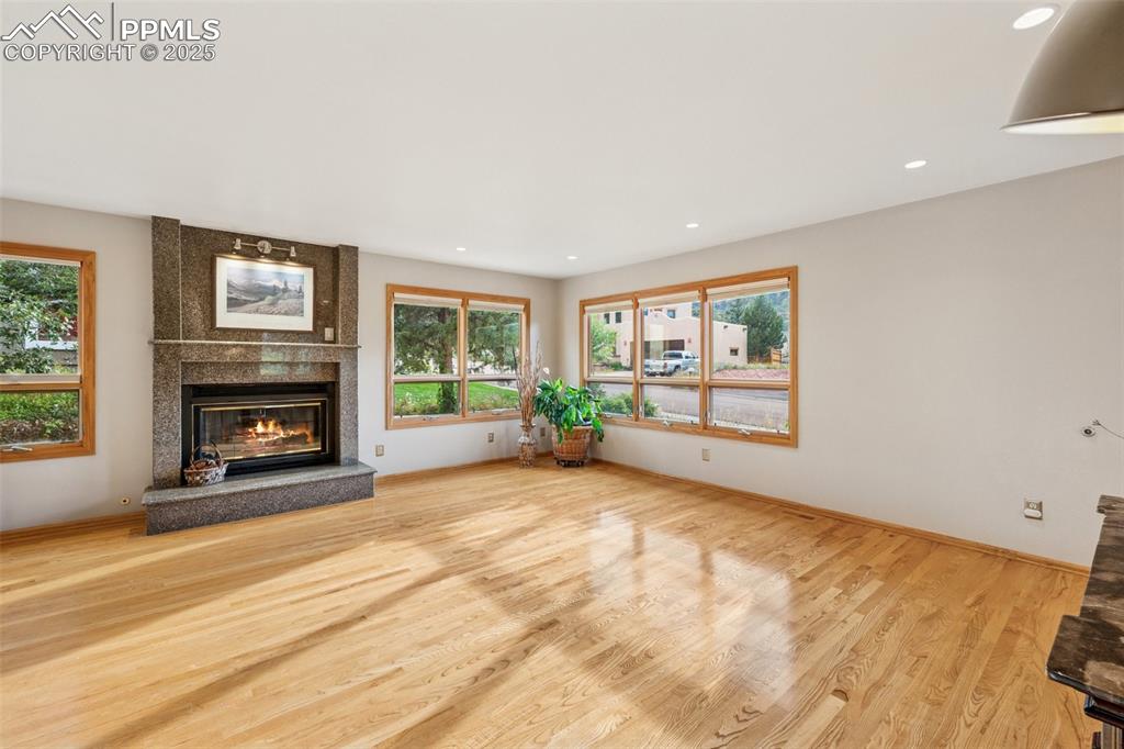 Image 11 of 50: West Facing Living Room, Natural Ash Wood Flooring, Gas & Wood Burning Fire