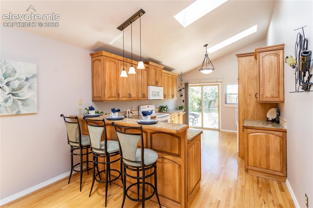 Image 10 of 48: Custom kitchen featuring wood cabinetry, light-toned countertops, and wood-