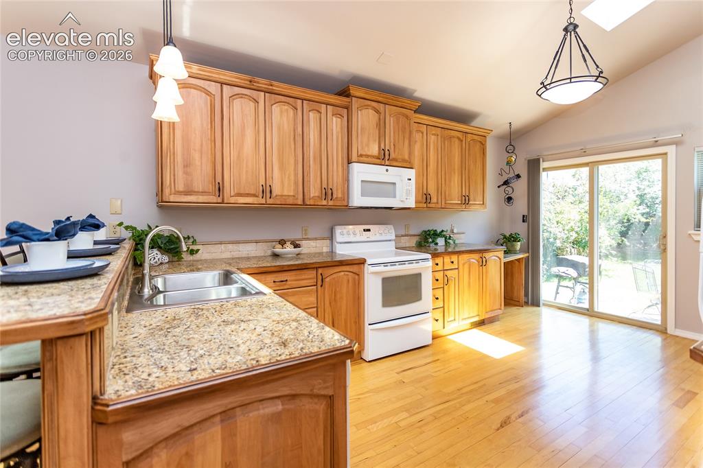 Image 12 of 48: Kitchen featuring maple wood cabinetry, granite-finish countertops, and lig
