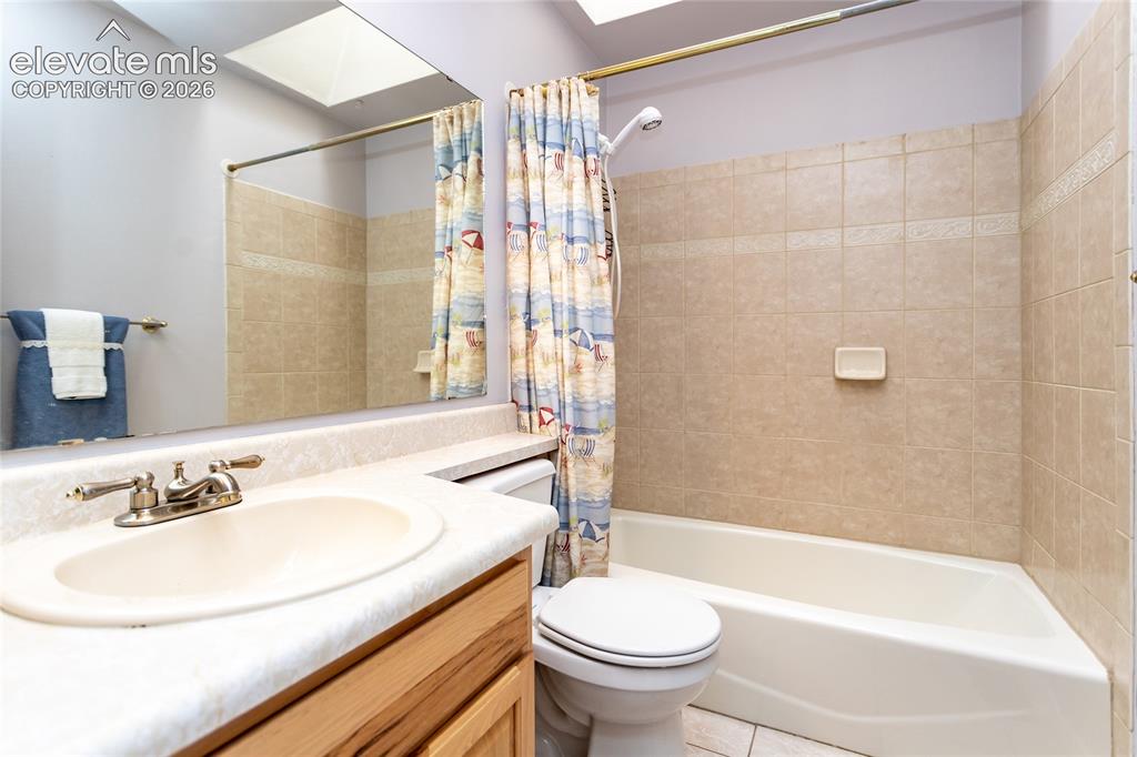 Image 17 of 48: Bathroom featuring a vanity with an integrated sink, a rectangular mirror, 
