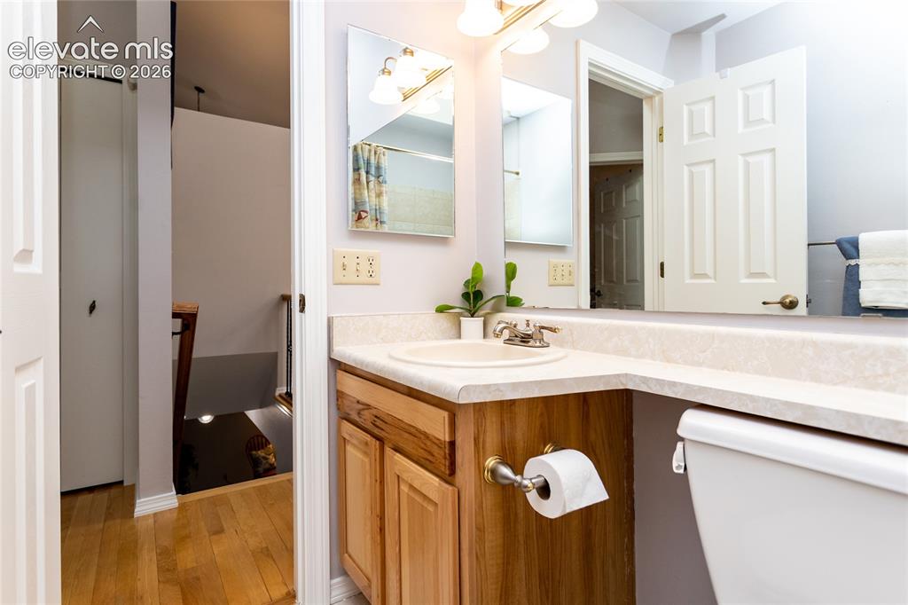 Image 18 of 48: Bathroom vanity with a light-toned countertop, integrated sink, and wood-fi