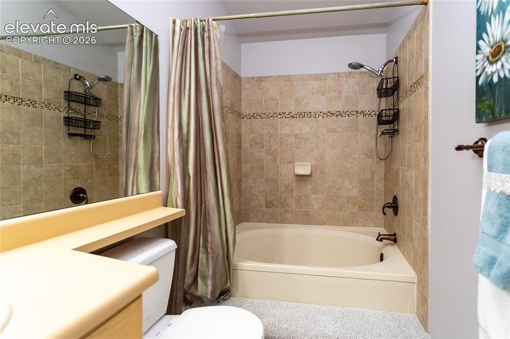 Image 25 of 48: Bathroom featuring a combination shower and tub with ceramic tile surround 