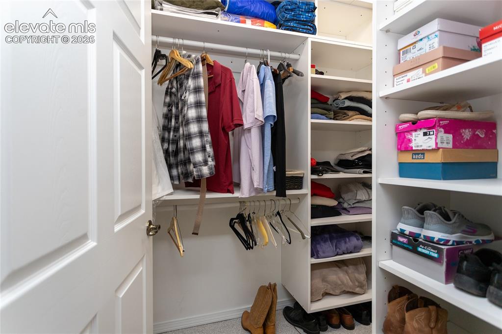 Image 27 of 48: Custom closet organization system featuring multiple hanging rods, adjustab