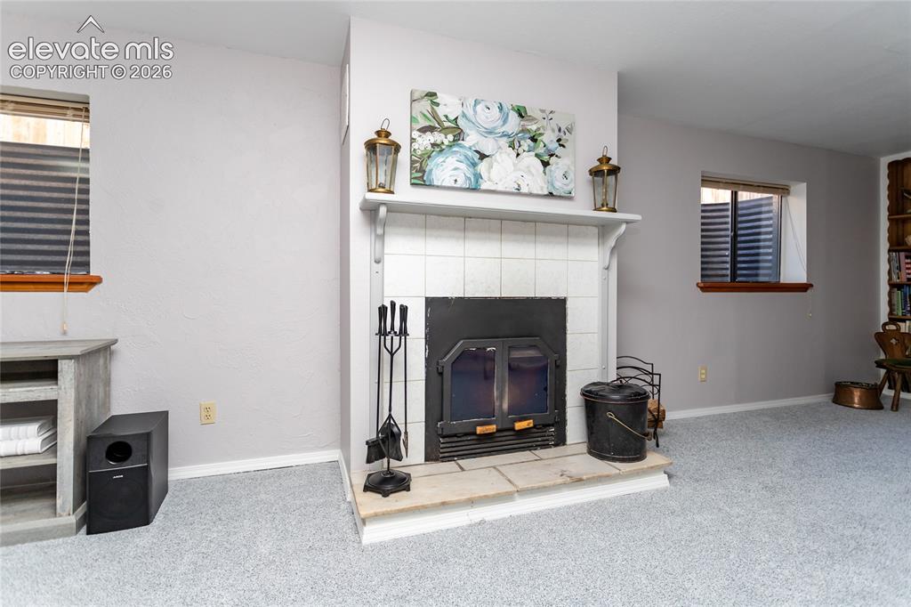 Image 30 of 48: Basement family room has wood burning stove