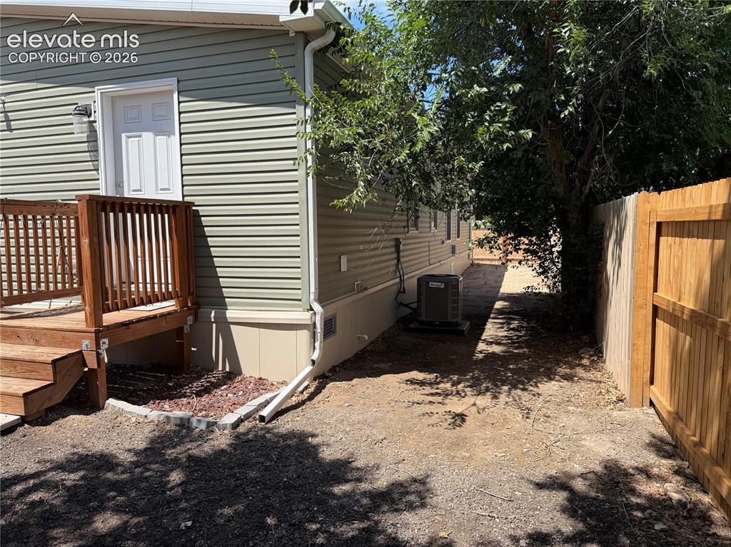 Image 25 of 27: Side yard where privacy fence was extended to give a full yard