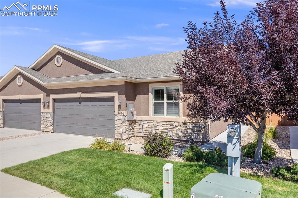 Image 4 of 44: View of front of home featuring stone siding, stucco siding, and driveway