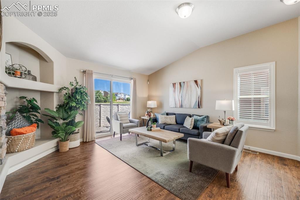 Image 6 of 44: Living room with wood finished floors and lofted ceiling