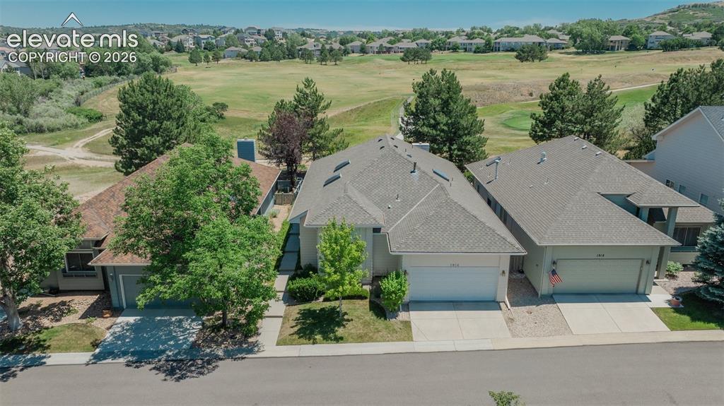 Image 1 of 46: Property with a golf course backdrop featuring a gravel yard, mature trees,