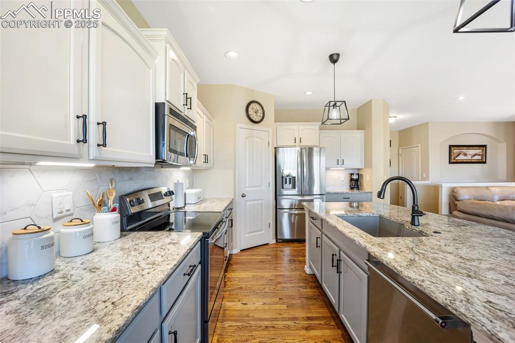 Image 14 of 50: Kitchen with appliances with stainless steel finishes, light wood-style flo