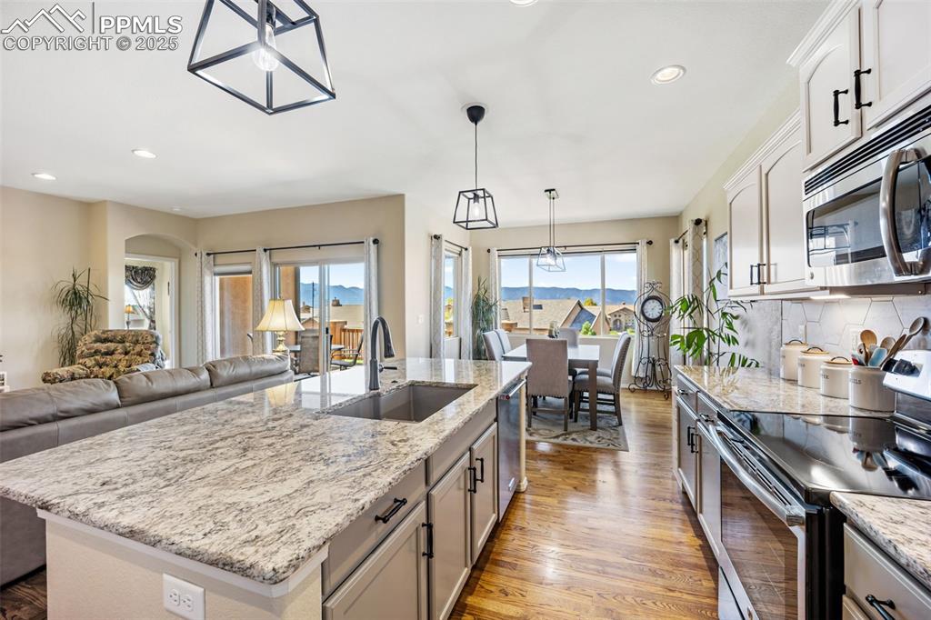 Image 16 of 50: Kitchen with appliances with stainless steel finishes, light wood-style flo