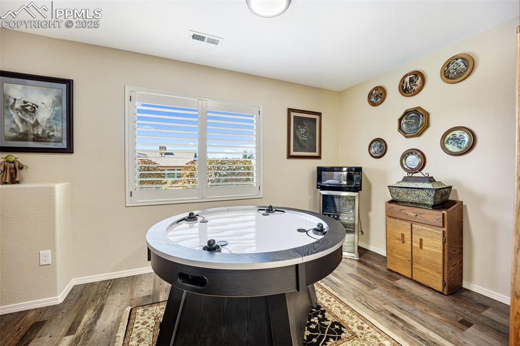 Image 31 of 50: Rec room with dark wood-style flooring