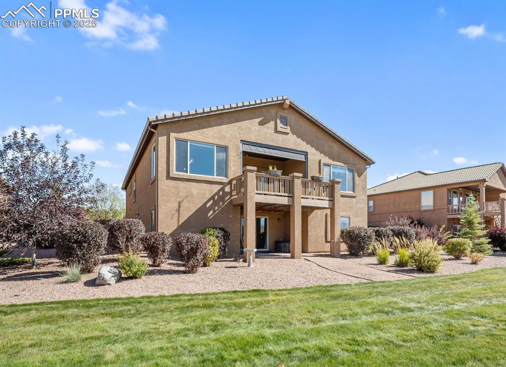 Image 43 of 50: Rear view of property featuring stucco siding, a yard, a patio area, and st