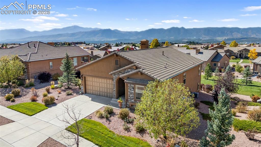 Image 44 of 50: View of front of home featuring stucco siding, a residential view, driveway