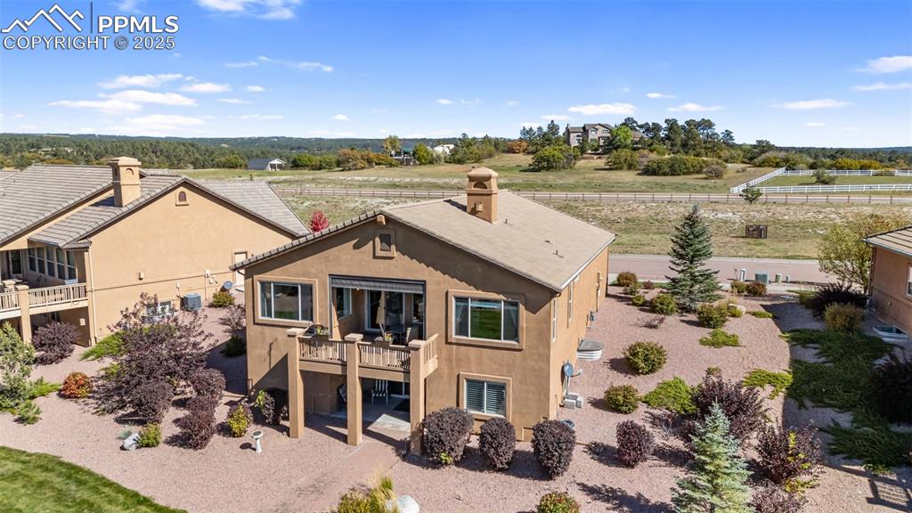 Image 46 of 50: Back of property with stucco siding, a wooden deck, a chimney, and a view o