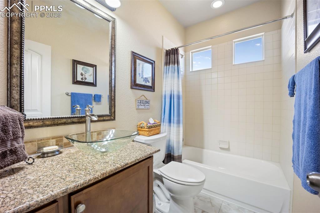 Image 7 of 50: Full bathroom with shower / bathtub combination with curtain, vanity, and a