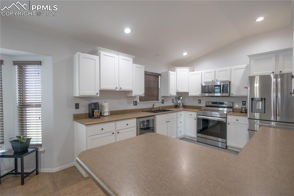 Image 16 of 34: Kitchen featuring appliances with stainless steel finishes, white cabinets,