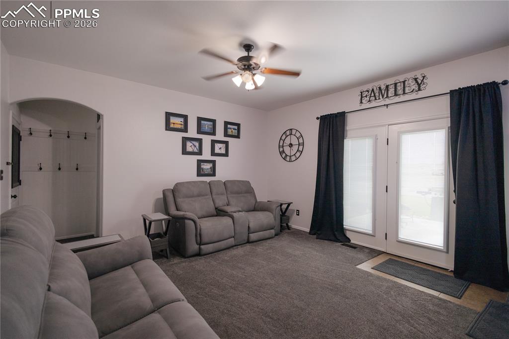 Image 18 of 34: Carpeted living room with ceiling fan