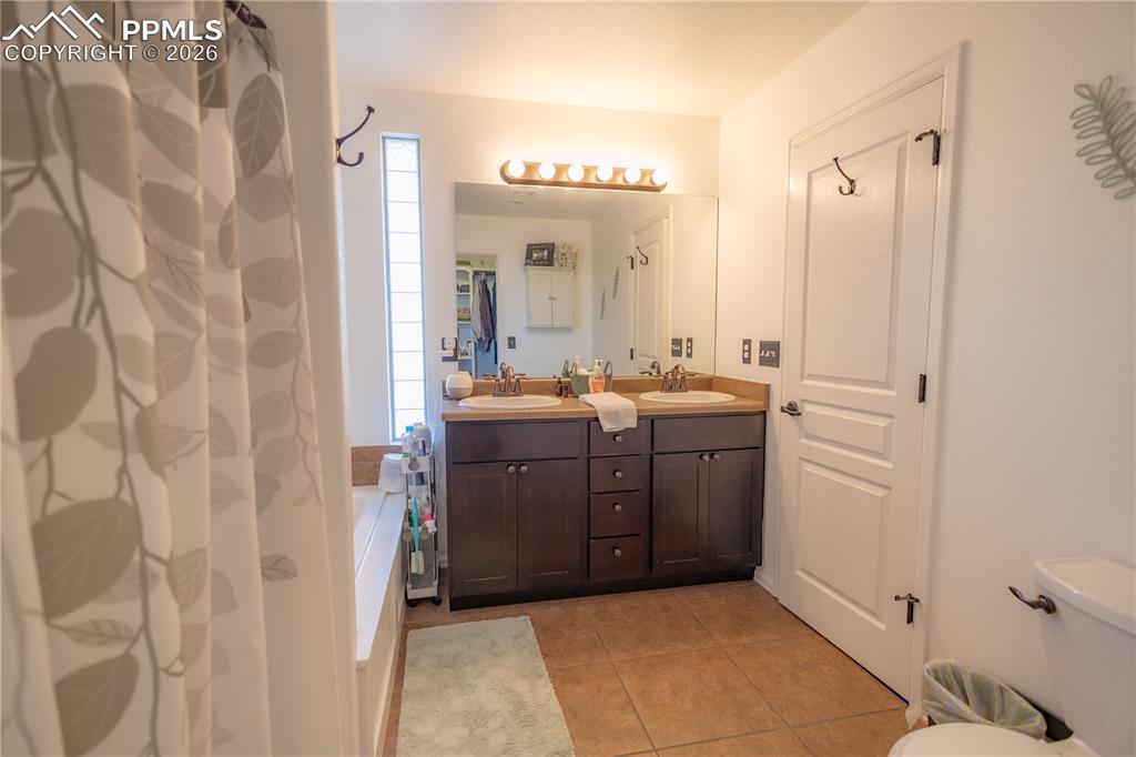 Image 27 of 34: Bathroom featuring double vanity and light tile patterned floors
