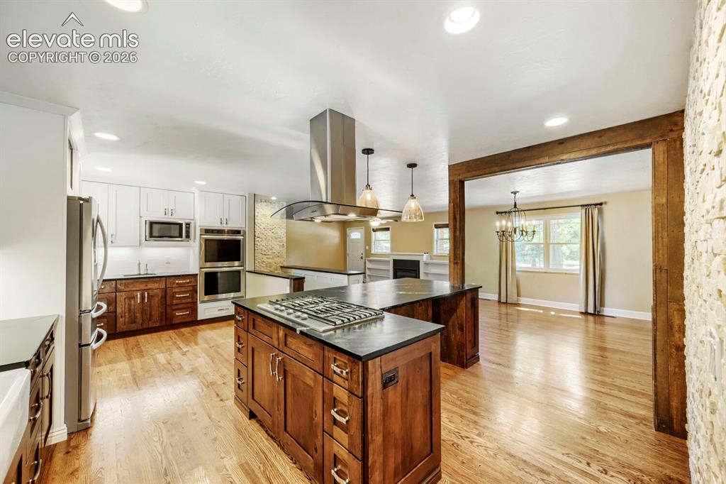 Image 11 of 41: Kitchen view to stovetop, hood, and dining area!