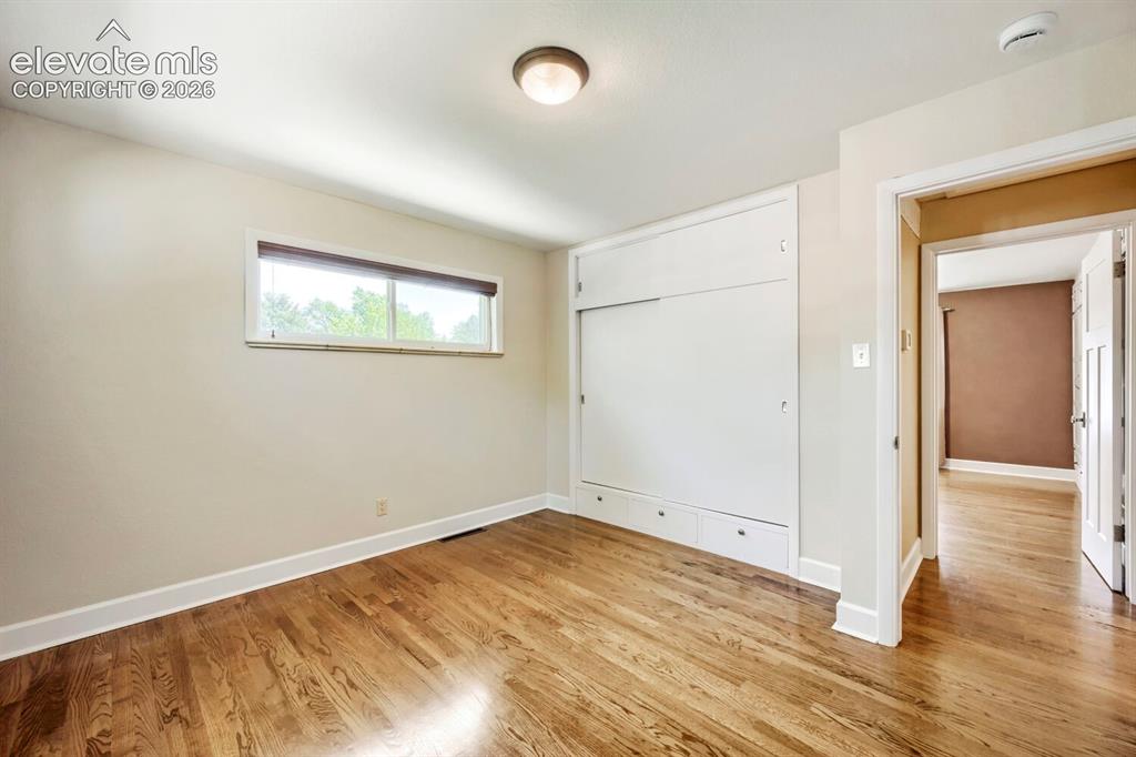 Image 19 of 41: Secondary main bedroom w/ hardwoods original wardrobe and sunny newer windo