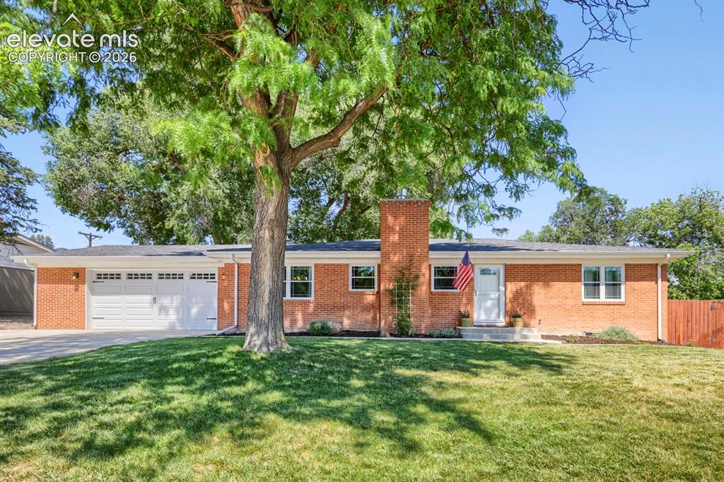 Image 3 of 41: Front of home with yard space and beautiful shade tree!