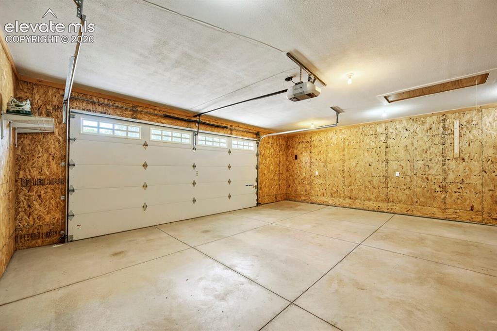 Image 35 of 41: Massive attached and fully insulated garage with man door to inside and to