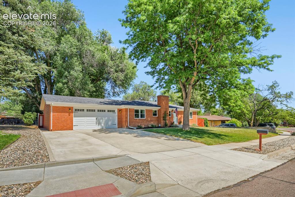 Image 4 of 41: Driveway and garage view of home with expansive space for vehicles.