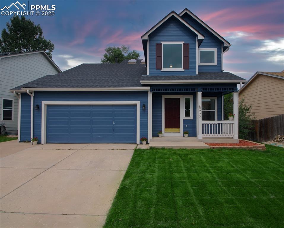 Caption: View of front of house with covered porch, a shingled roof, an attached garage, and driveway