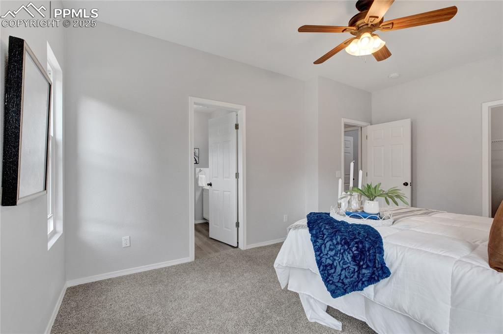 Image 16 of 44: Bedroom featuring light carpet, a ceiling fan, and connected bathroom