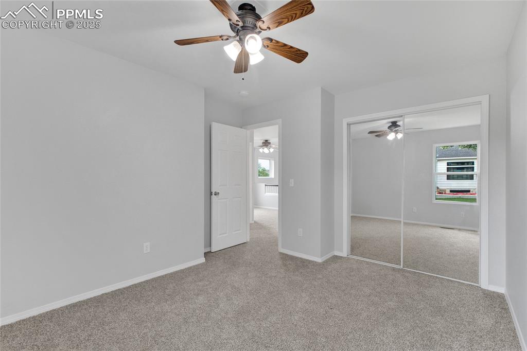 Image 23 of 44: Unfurnished bedroom featuring light carpet, multiple windows, a closet, and