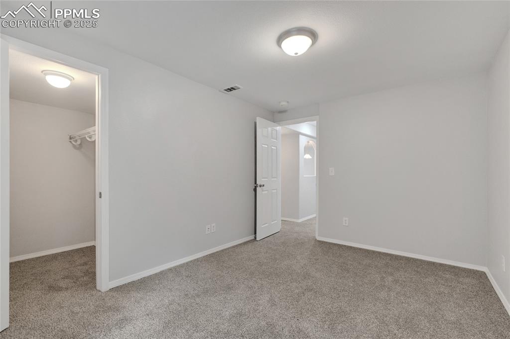 Image 34 of 44: Unfurnished bedroom featuring a walk in closet and carpet flooring