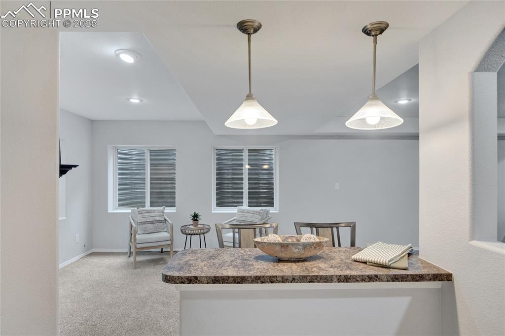 Image 36 of 44: Kitchen featuring dark countertops, carpet flooring, pendant lighting, and 