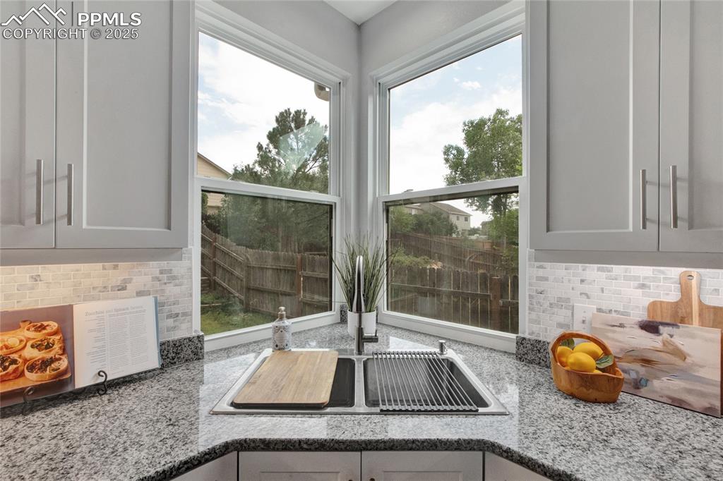 Image 9 of 44: Kitchen view of backsplash and light stone counters