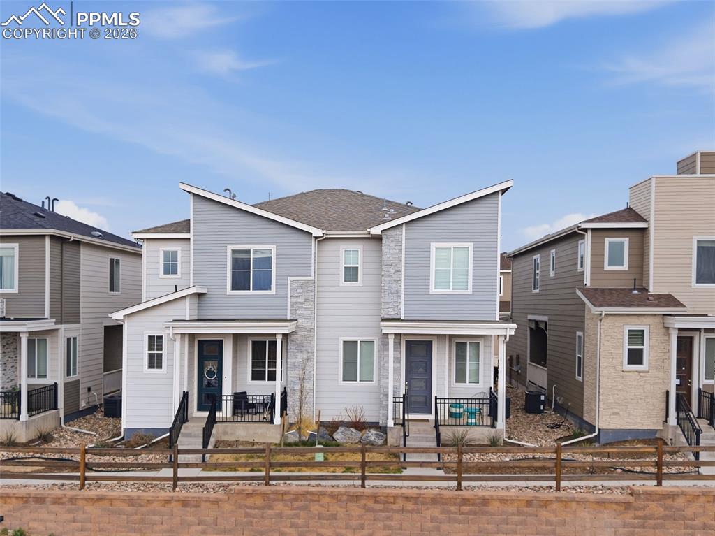 Caption: Exterior Front – Attractive modern townhome exterior with contemporary architectural lines, stone ac
