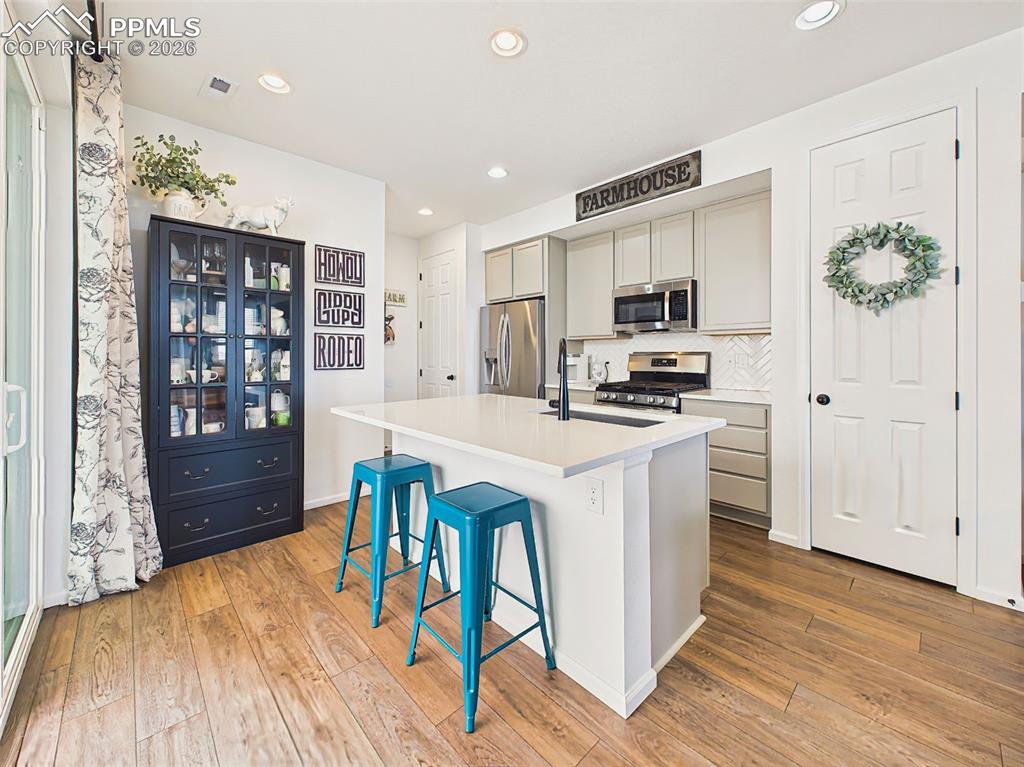 Image 15 of 50: Kitchen – Bright and airy kitchen with oversized quartz island, stainless s