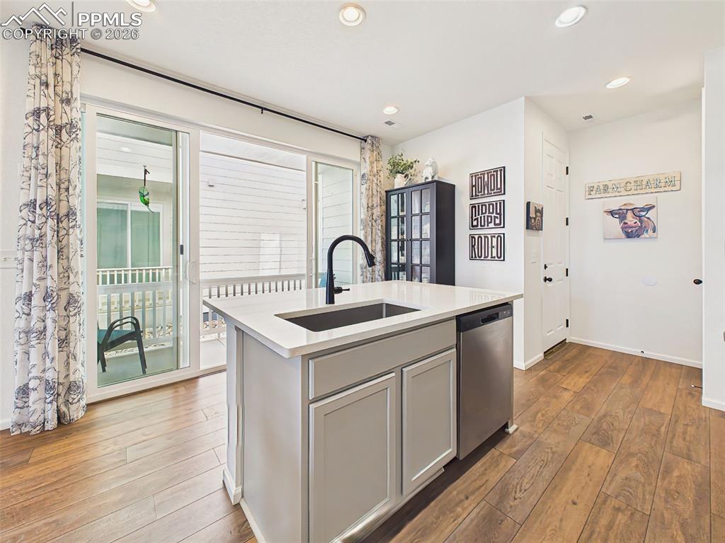 Image 17 of 50: Kitchen / Outdoor Access – Functional kitchen layout with island sink and d