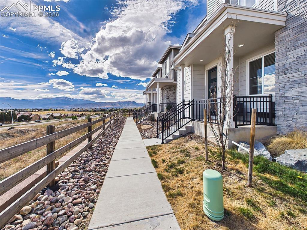 Image 38 of 50: Exterior – Front walkway and entry with attractive landscaping and covered 