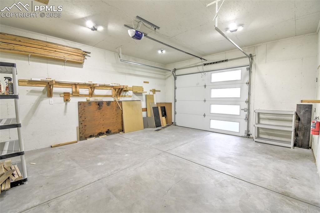 Image 21 of 25: Garage featuring a garage door opener
