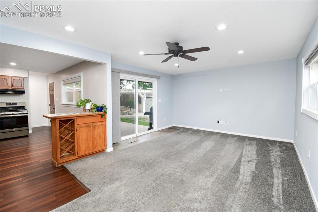 Image 9 of 25: Unfurnished living room featuring recessed lighting, a ceiling fan, dark ca