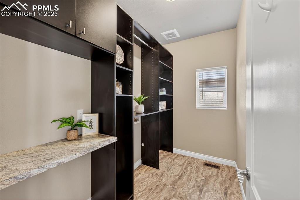 Image 25 of 34: Full bathroom with double vanity, a spacious closet, a bath, a shower stall