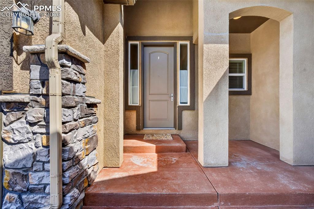 Image 4 of 34: Doorway to property featuring stucco siding