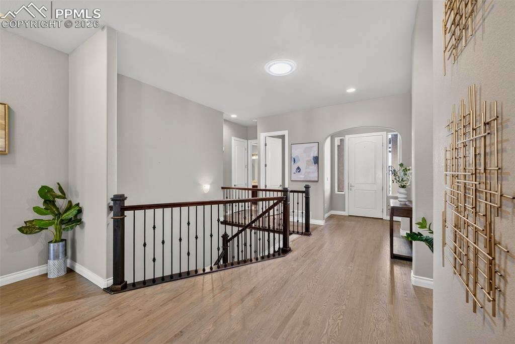 Image 5 of 34: Hallway featuring an upstairs landing, light wood finished floors, arched w