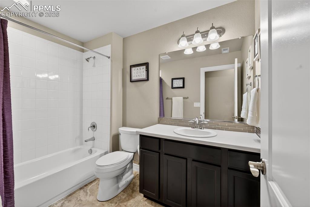 Image 6 of 34: Full bath featuring vanity, shower / tub combo, and decorative backsplash