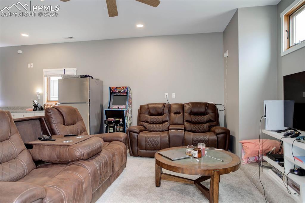 Image 23 of 28: Living area featuring a ceiling fan, recessed lighting, light colored carpe