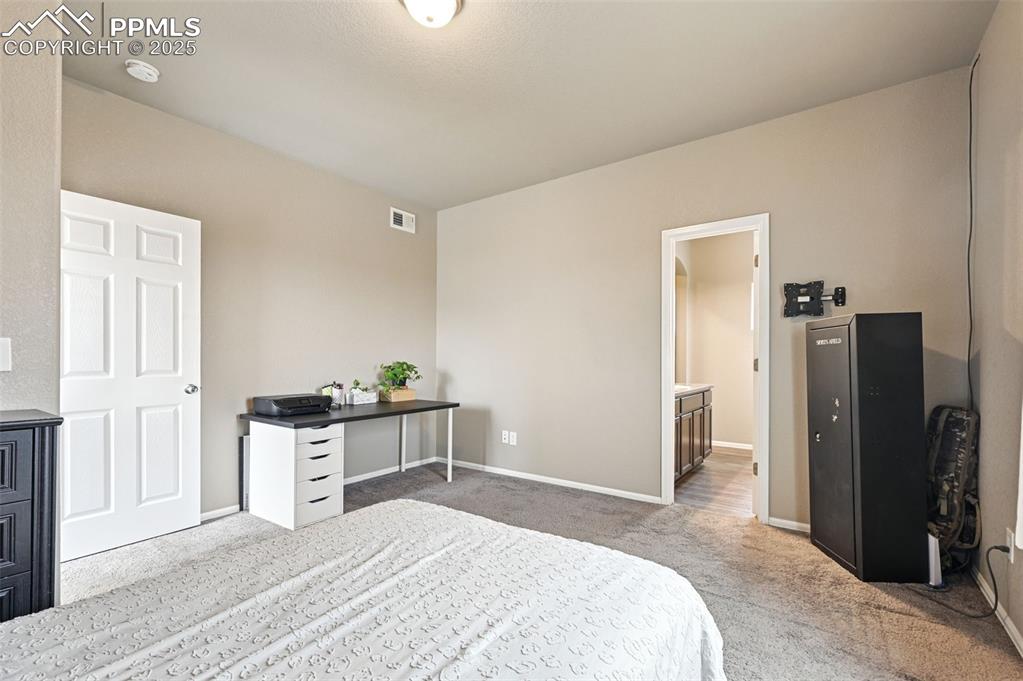 Image 13 of 29: Bedroom featuring light colored carpet and ensuite bathroom