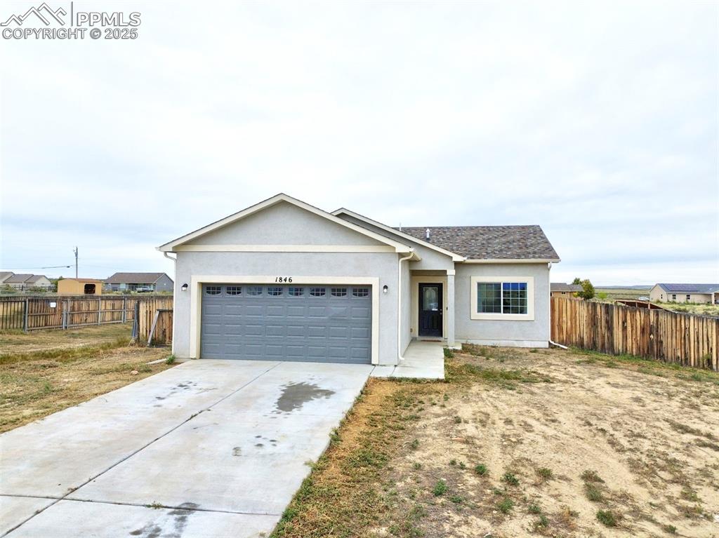 Image 2 of 29: Ranch-style home featuring stucco siding, concrete driveway, and an attache