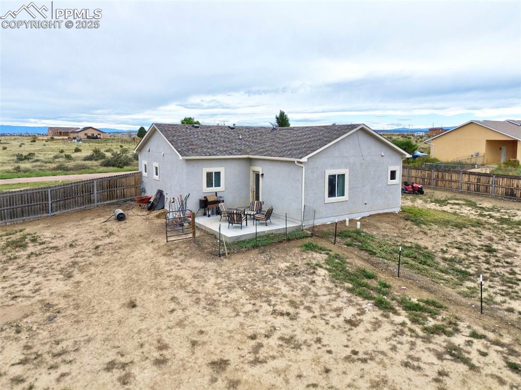 Image 25 of 29: Rear view of house with a patio area, stucco siding, and a fenced backyard