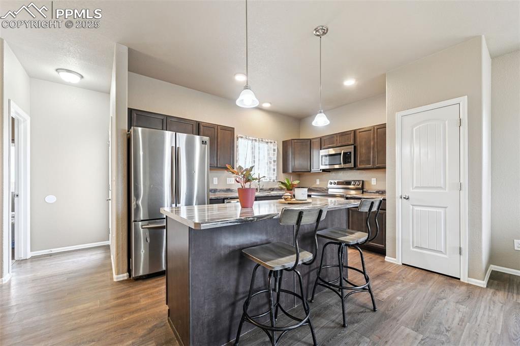 Image 5 of 29: Kitchen with dark brown cabinets, appliances with stainless steel finishes,