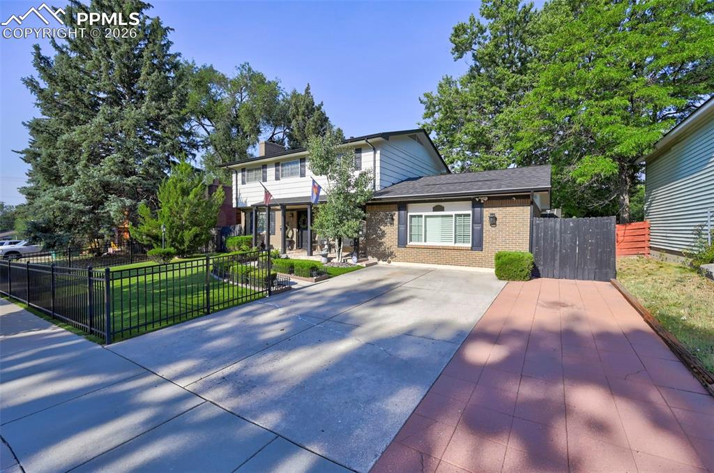 Image 1 of 46: View of front of property with brick siding, a patio area, and driveway